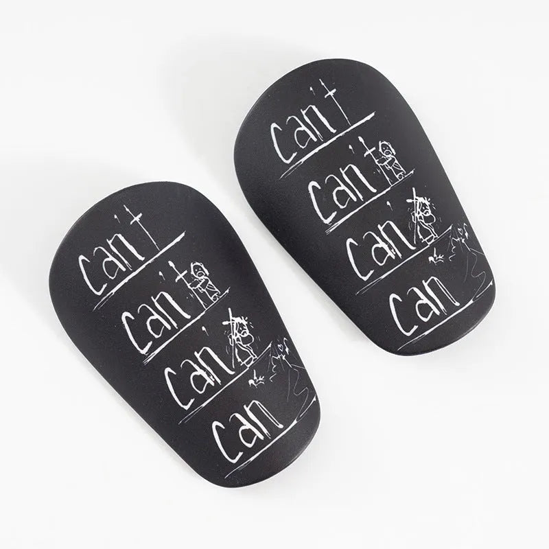 A pair of white and black PU football shin guards for S and XS sizes.