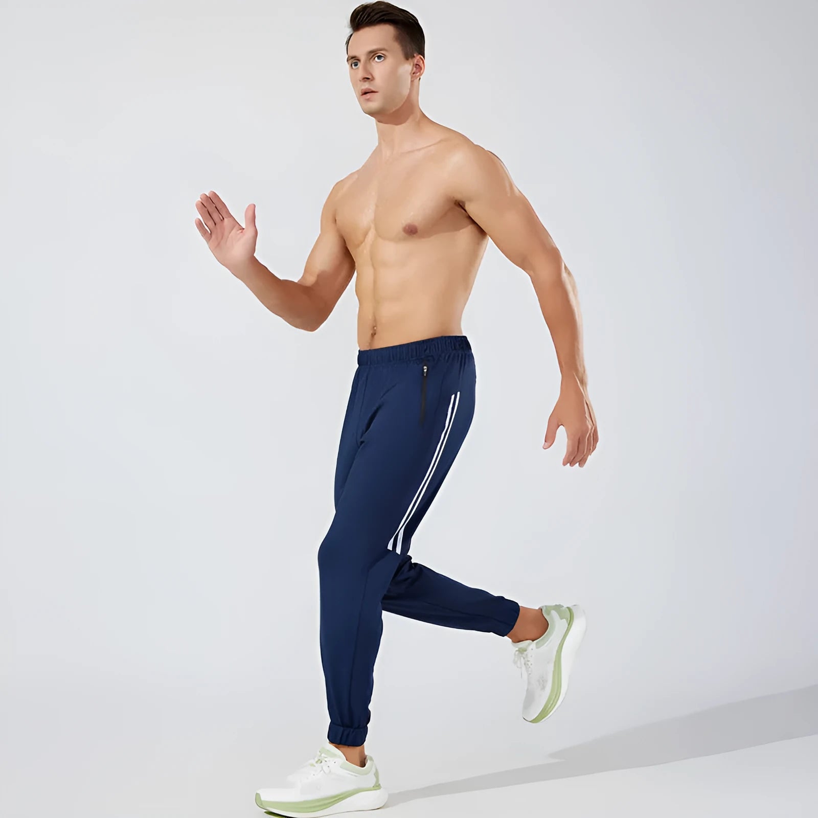 Men's black polyester running trousers with a mid waist fit on a size chart.