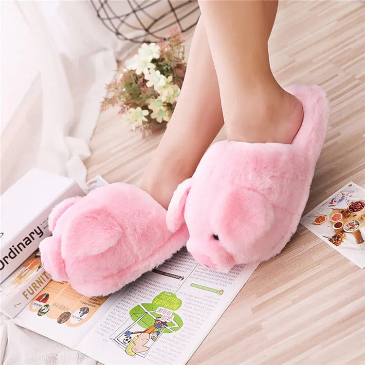 Pink pig-shaped plush floor slippers with a soft, textured surface and cushioned sole.
