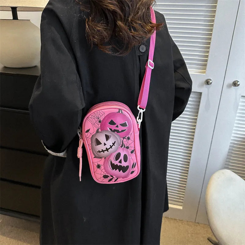 Women's black mini crossbody bag with orange Halloween pumpkin graffiti print.