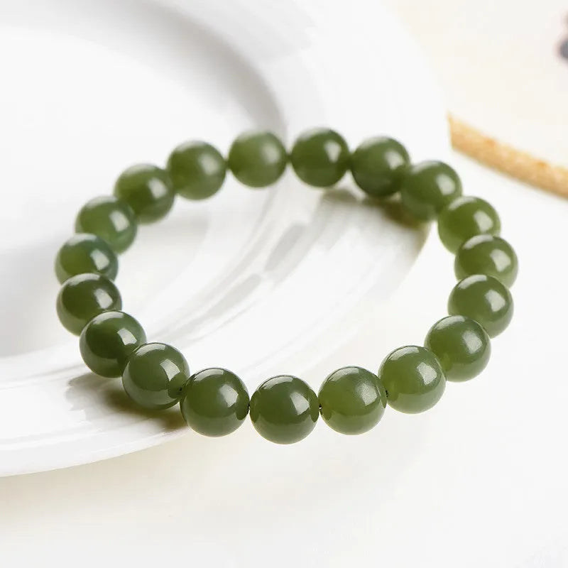 Polished Hetian jade ball bead bracelet in clear colour on wrist, showing spherical beads.