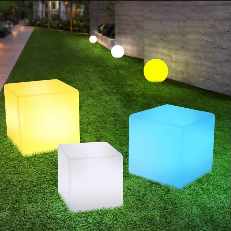 White square LED cube stool light on patio, modern outdoor seating with integrated lighting.