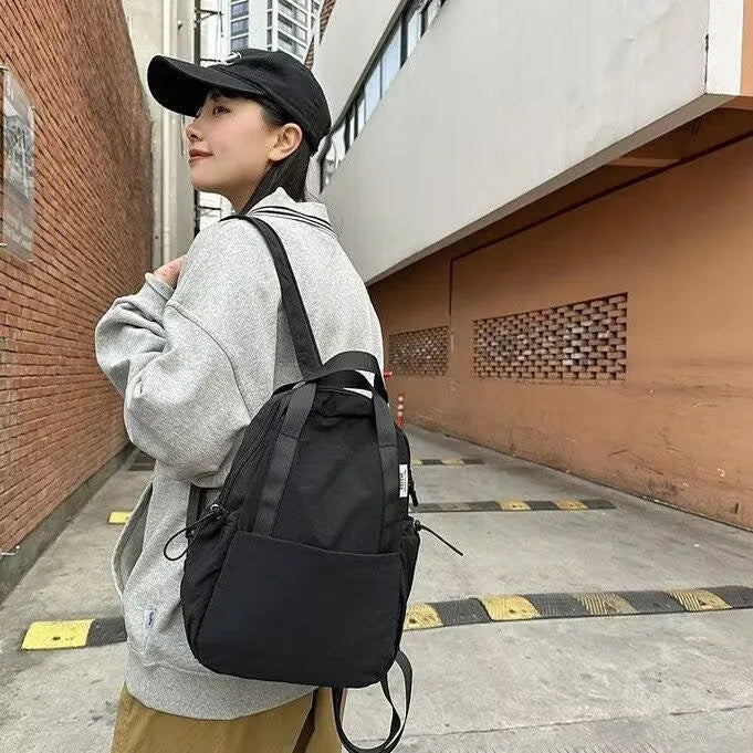 Solid colour nylon backpack with curved shoulder straps and a lock closure.