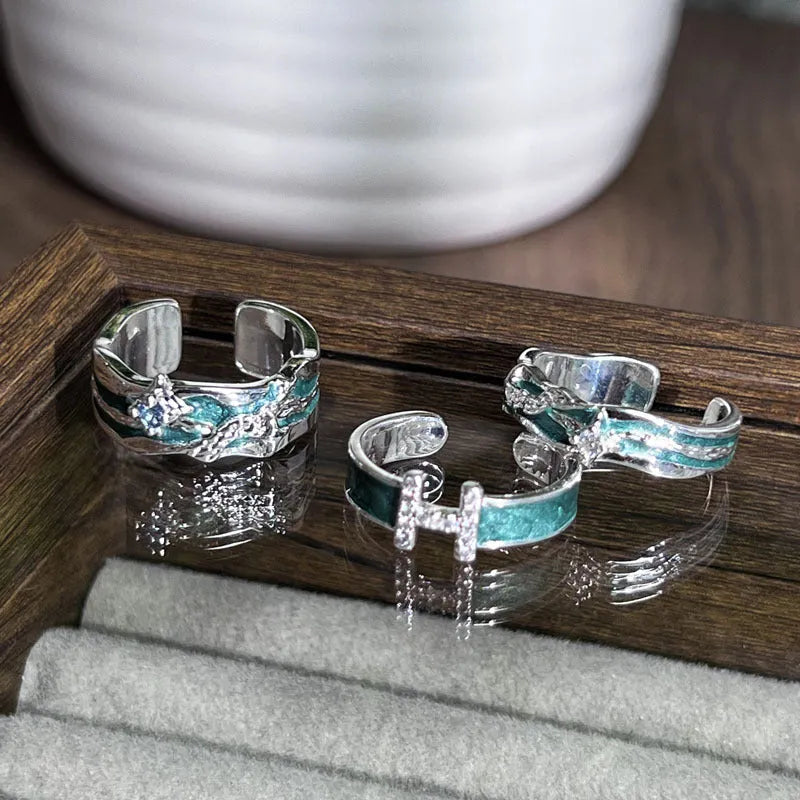 Mint green enamel asterism ring with copper base and eight-point star pattern on finger