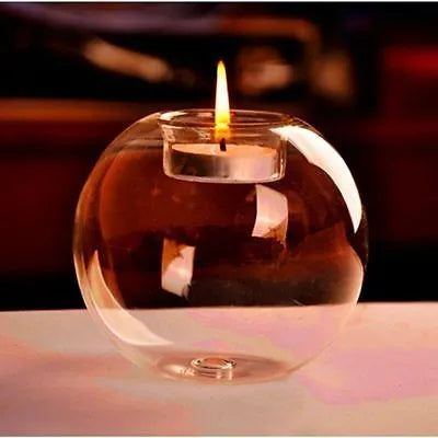 Clear round handmade hollow glass candle holder sphere on a table.