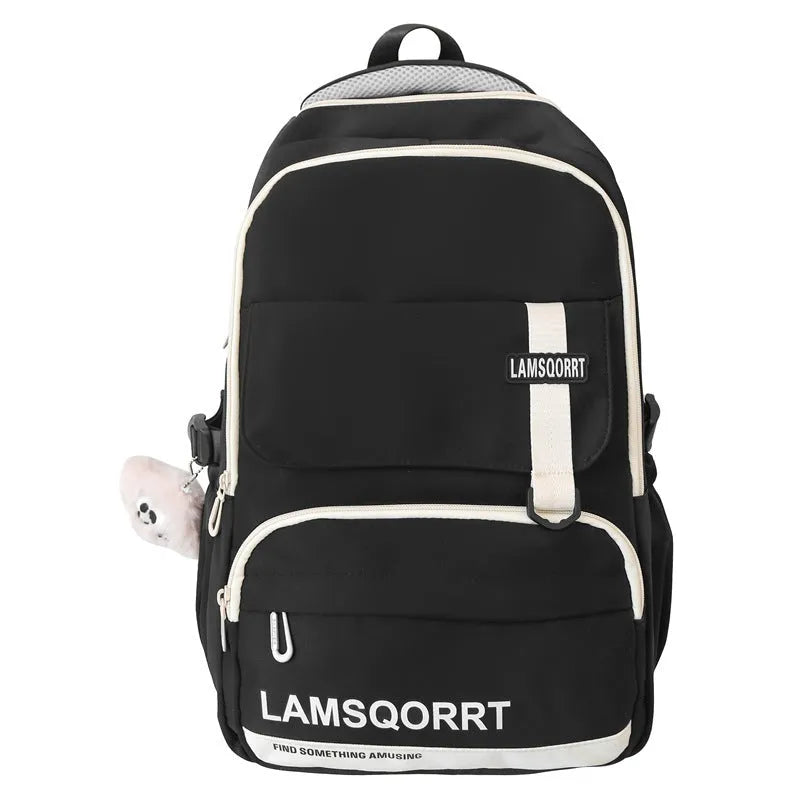 Nylon school backpack in green with pendant, showing curved shoulder straps and sewing line detail.