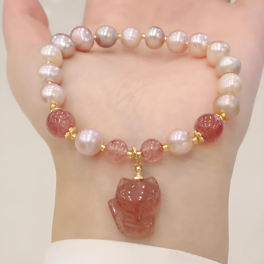 Women's light pink freshwater pearl bracelet with strawberry quartz and fox charm detailing