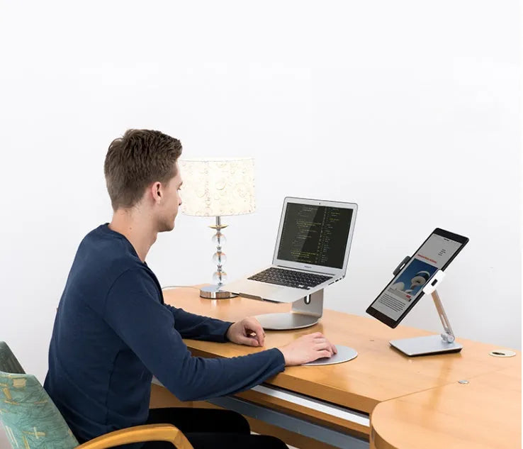 Folding aluminium phone and tablet stand with black silicone pads, shown holding a tablet at an angle.