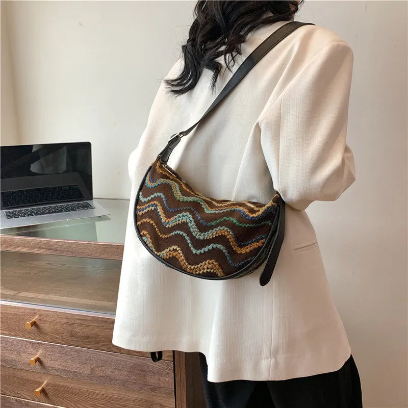Women's woven straw crossbody bag showing internal phone pocket and document compartment