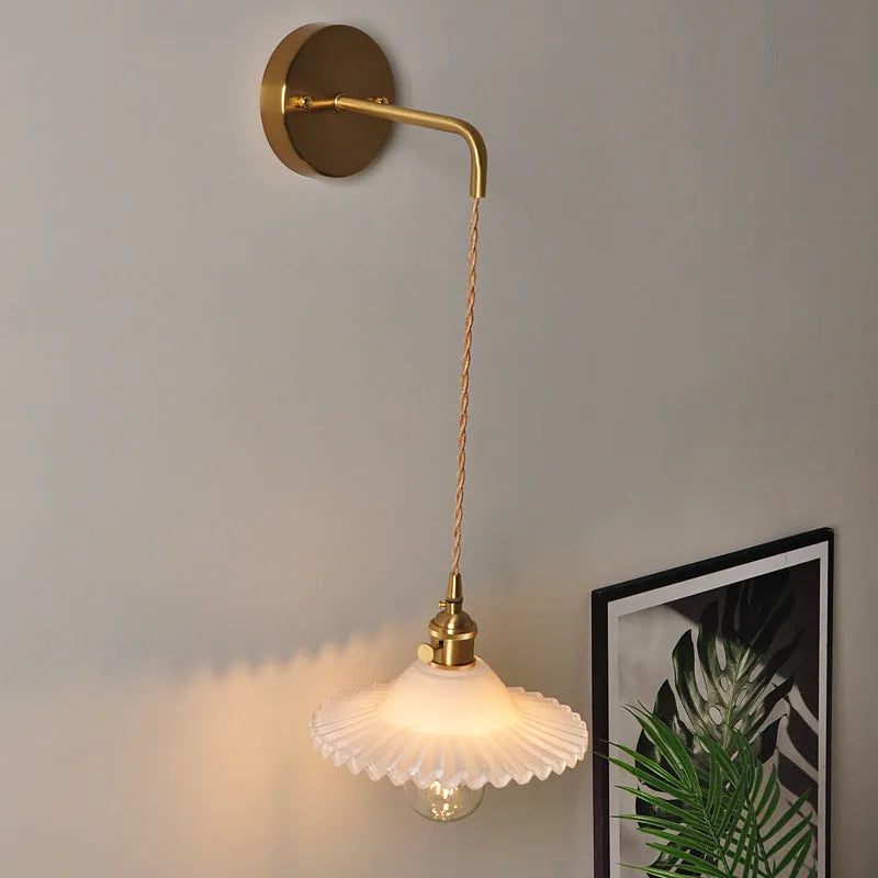 Retro brass lotus wall lamp with copper frame and glass shade on a wall