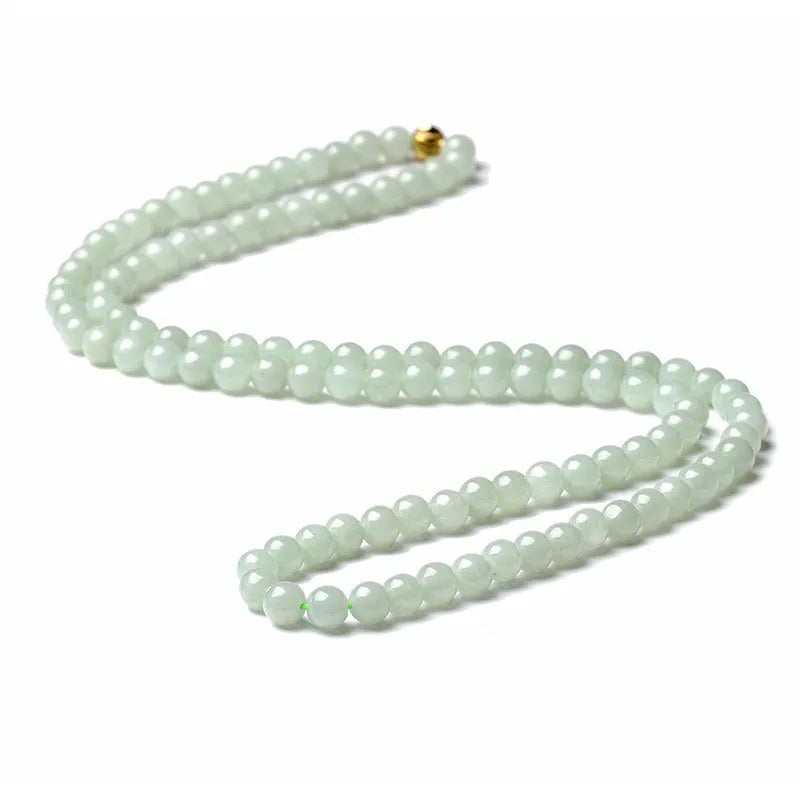 Close-up of a women's adjustable necklace with round white and green natural jade beads on a metal chain.