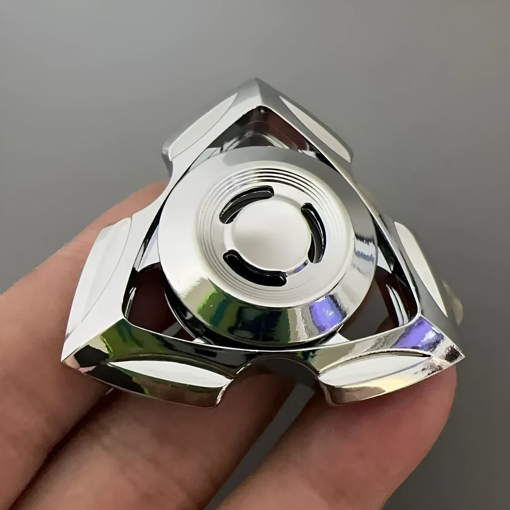 A silver alloy fingertip gyro decompression toy with a central spinning bearing.