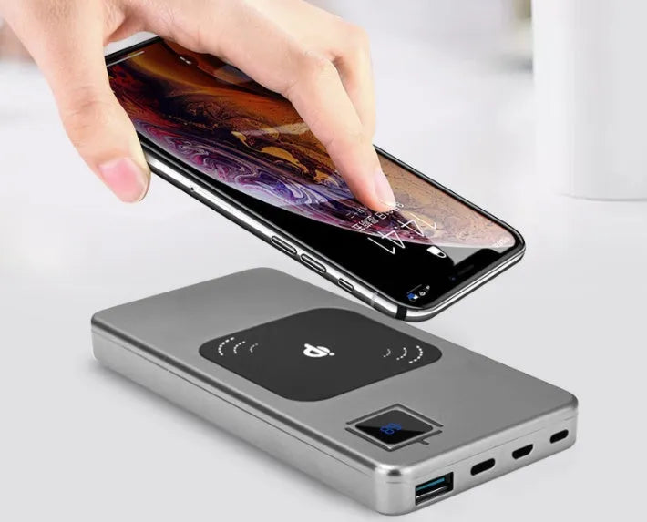 A black portable power bank with an LCD screen showing battery percentage, alongside silver, red, and blue colour options.