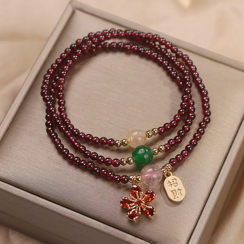Women's simple bracelet made of red crystal with sequin accents on a wrist.