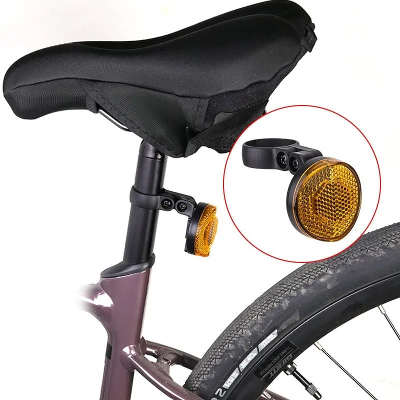 Red plastic bicycle taillight bracket mounted on seat post with reflective elements