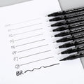 Set of 12 black comic hand-painted pens with various nib sizes in a storage bag organiser
