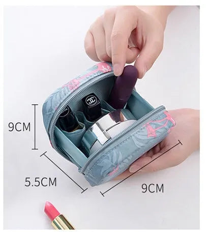 A blue cloth cube-shaped makeup storage bag with a plain pattern, sitting on a surface.