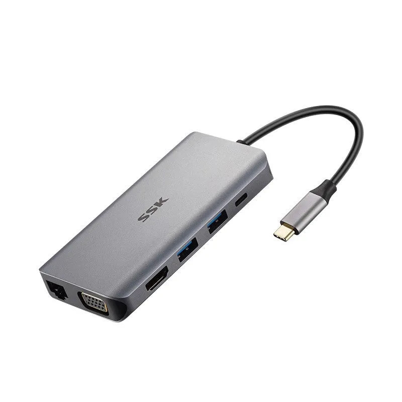 Grey 11-in-1 USB-C docking station with HDMI, VGA, USB ports, Ethernet, and card reader on a desk.