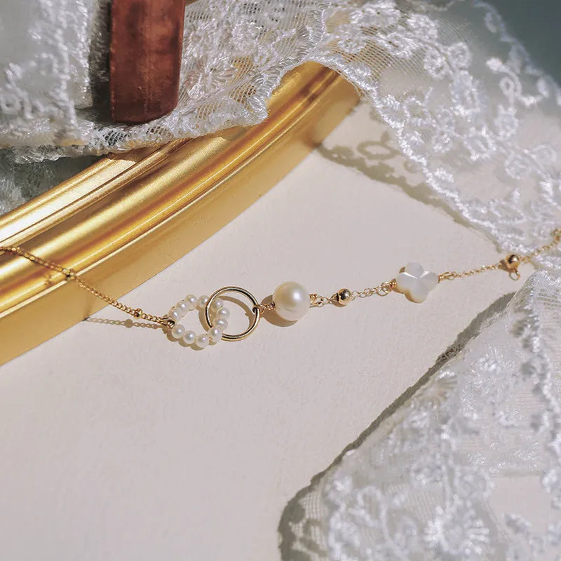 Women's natural pearl bracelet with 14k gold-plated clasp and chain.