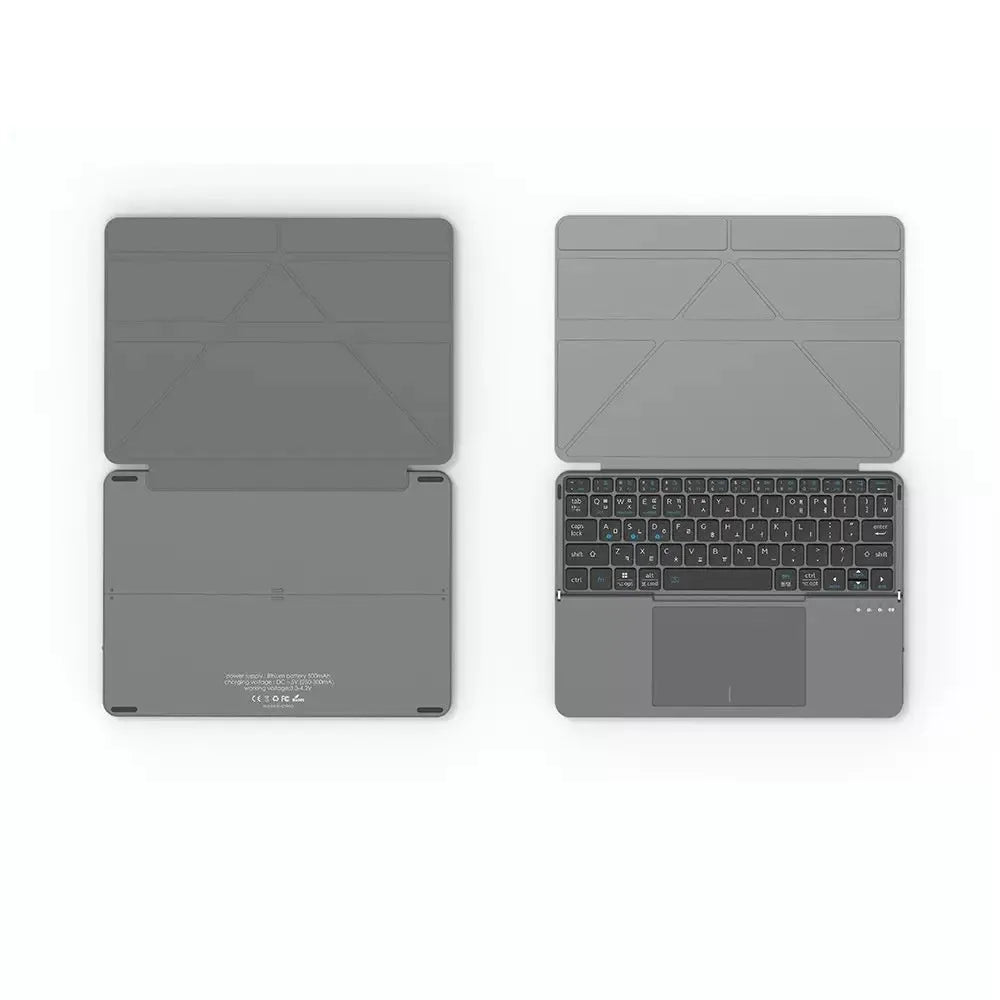 Grey wireless Bluetooth folding keyboard for mobile phones and tablets on a table.