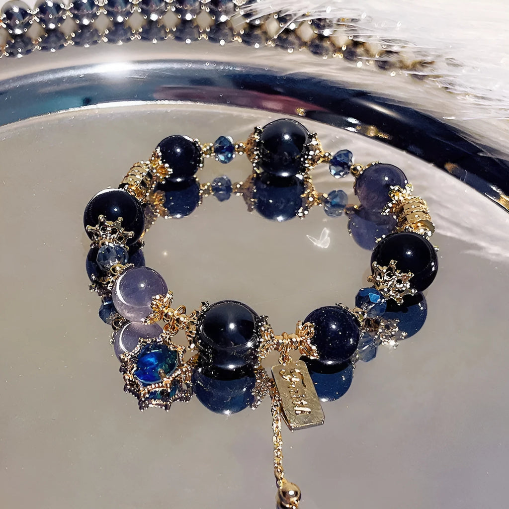 Galaxy-coloured alloy charm bracelet with snowflake, heart, and bow pendants.