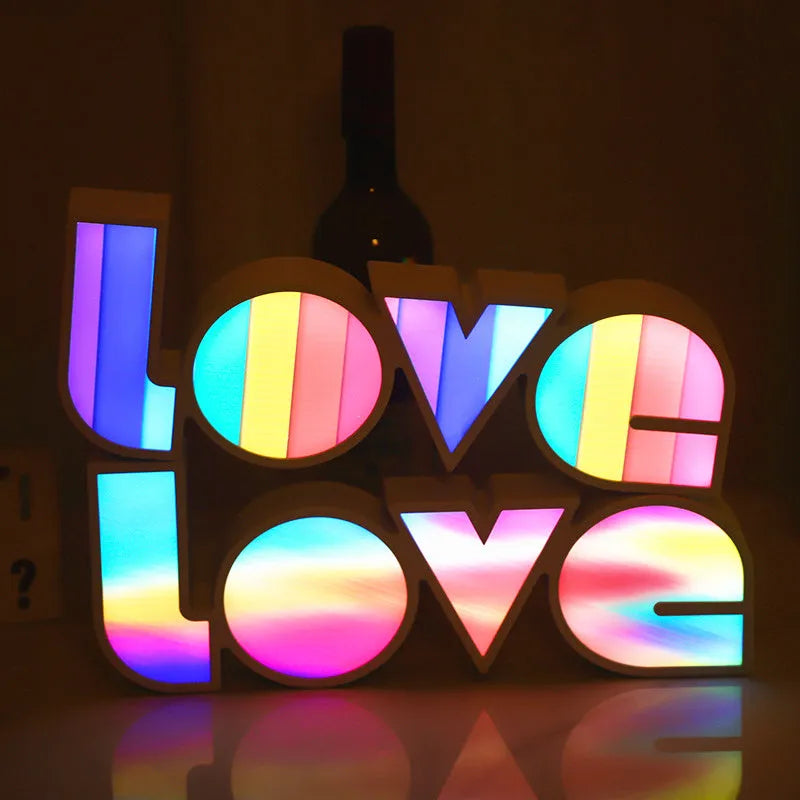 Rainbow-style plastic LED decorative light spelling LOVE, shown on a table.