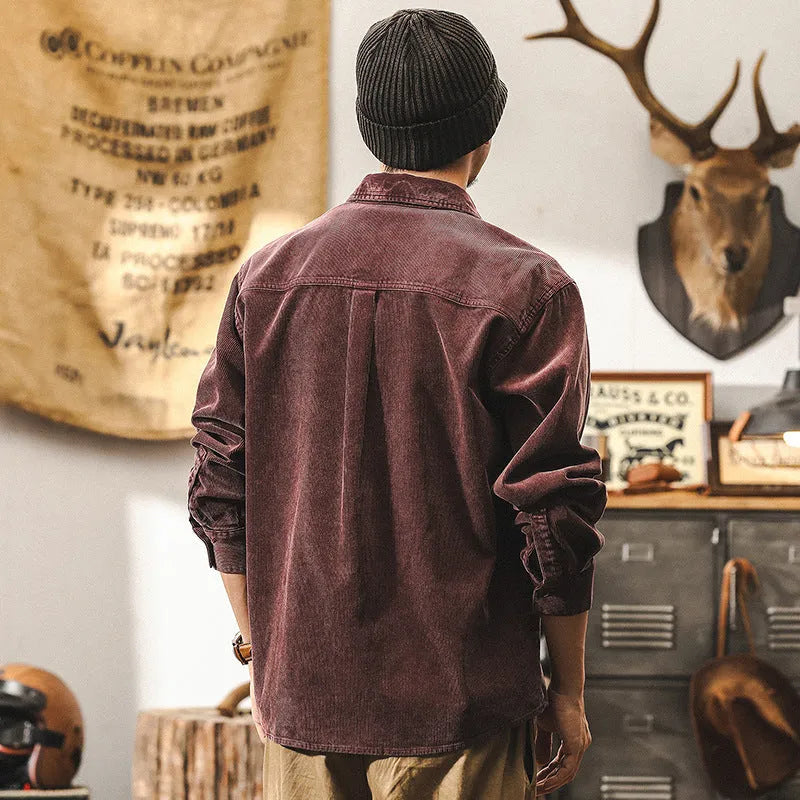 Man wearing a loose-fit red corduroy shirt jacket, showcasing its textured fabric and casual style.