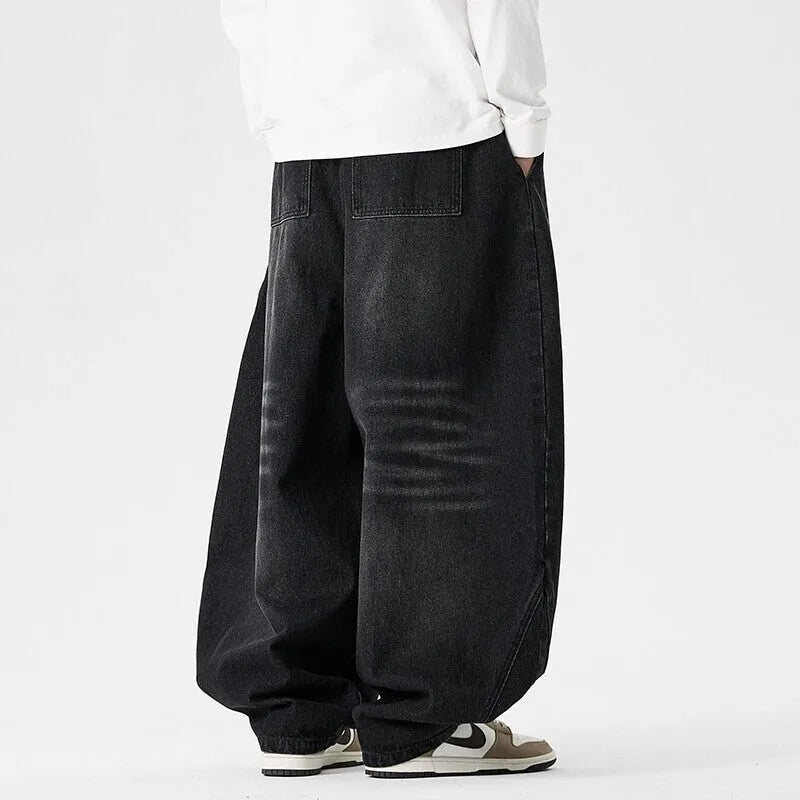 Man wearing light blue baggy fit denim jeans with a straight leg and low waist.