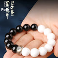 Black and white Taiji symbol bracelet made from obsidian beads with engraved mantra.