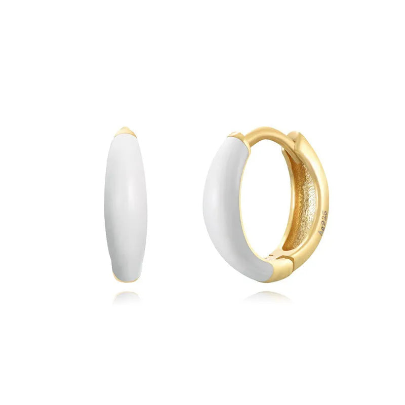 Pair of curved oval epoxy earrings in geometric ring design on a U-shaped hook.