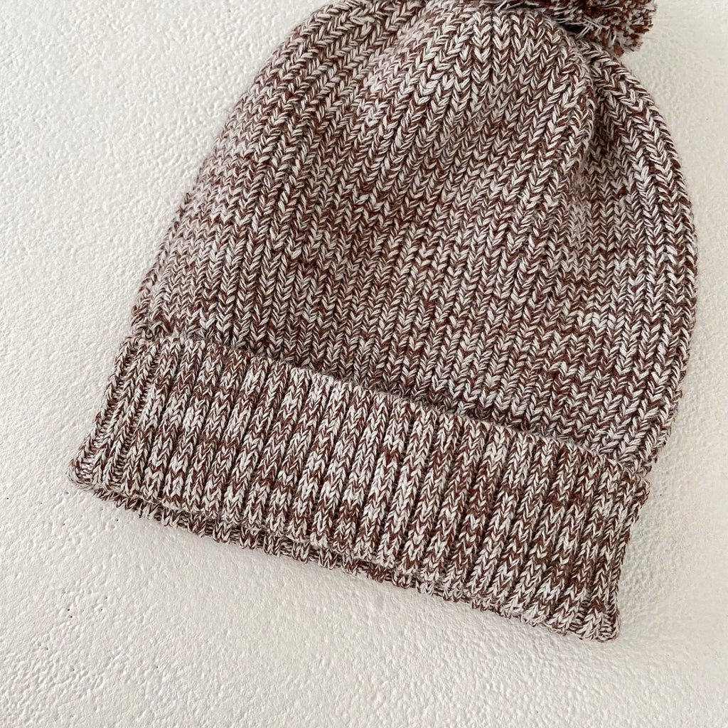 Dark brown knitted 3-piece set for infant girl with pullover blouse, pants, and fur ball hat