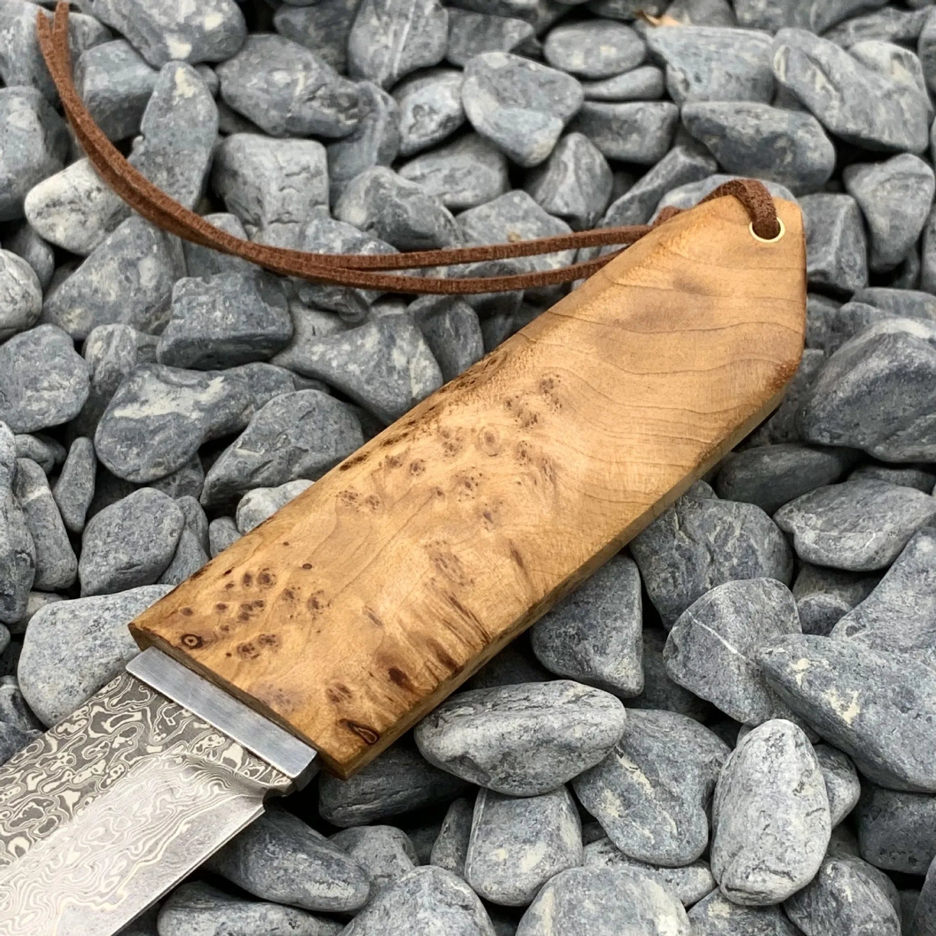 White Shadow Damascus steel short knife with Thuja wood handle, showing blade pattern.
