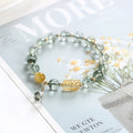 Green phantom quartz bracelet with 8mm geometric beads and gold rutile inclusions on wrist
