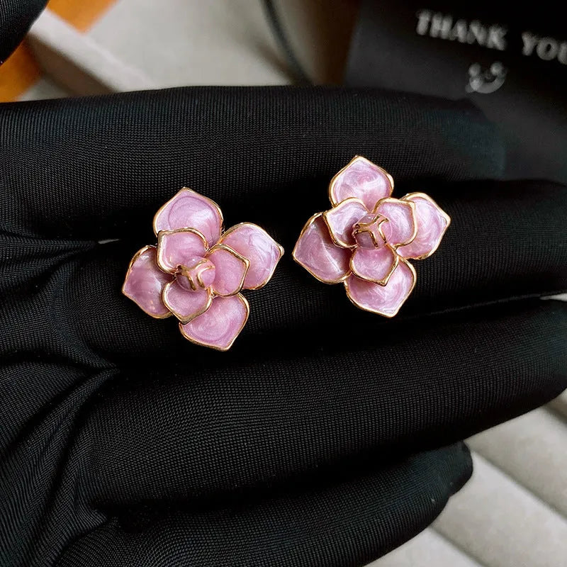 Close-up of gold plated purple oil-spot glaze flower stud earrings on a copper base.