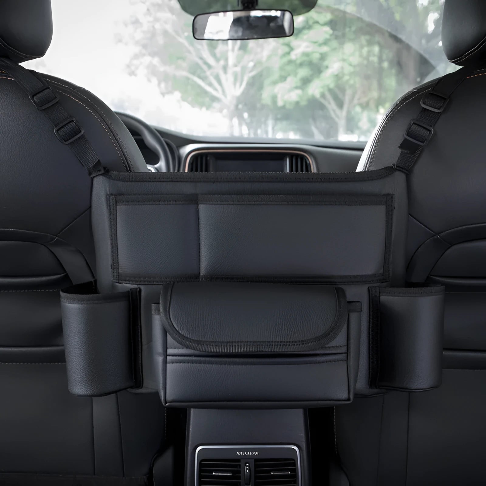 Black leather car seat hanging storage organiser for tissue boxes, shown between vehicle front seats.