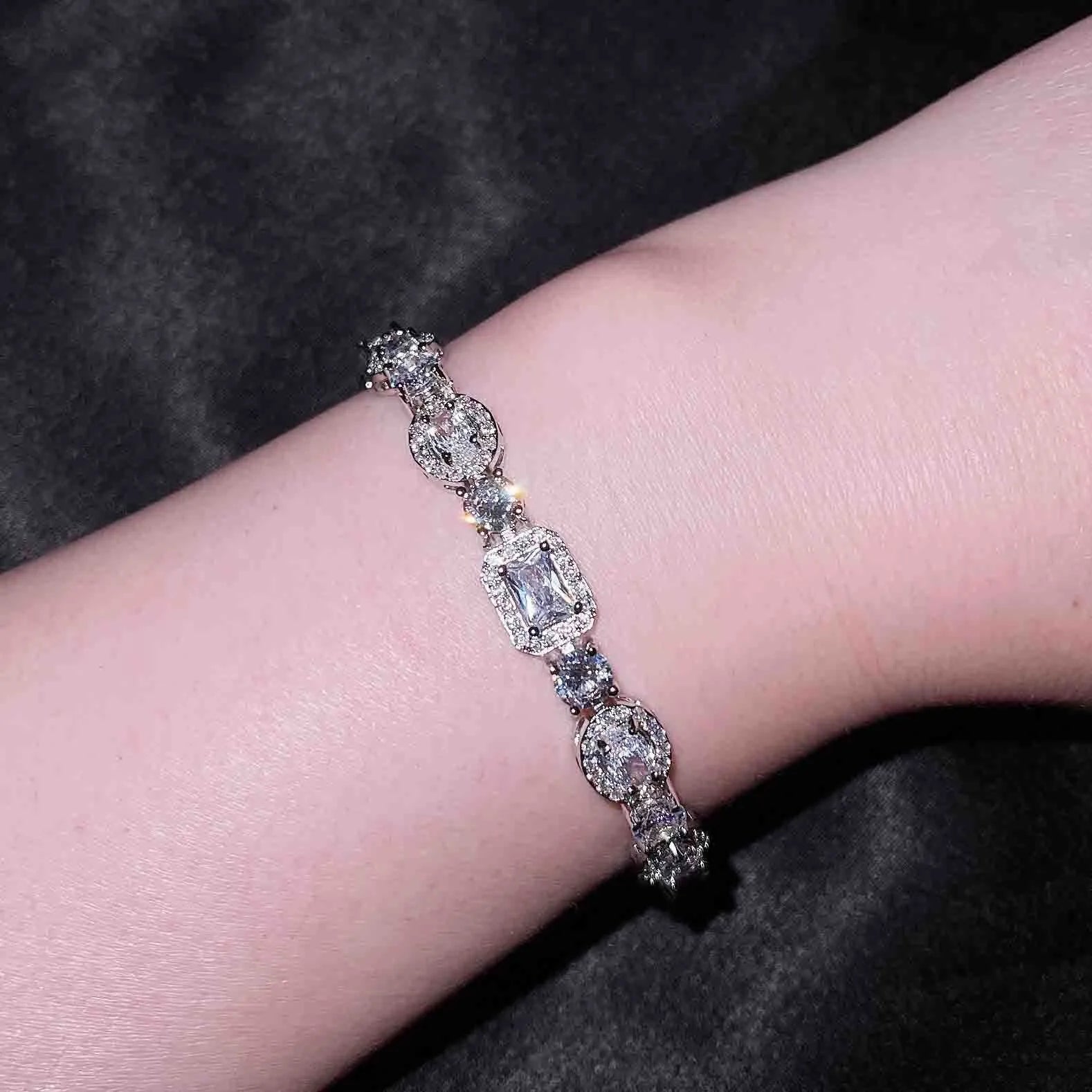Women's silver-toned geometry bracelet with inlaid clear stones on a model's wrist.