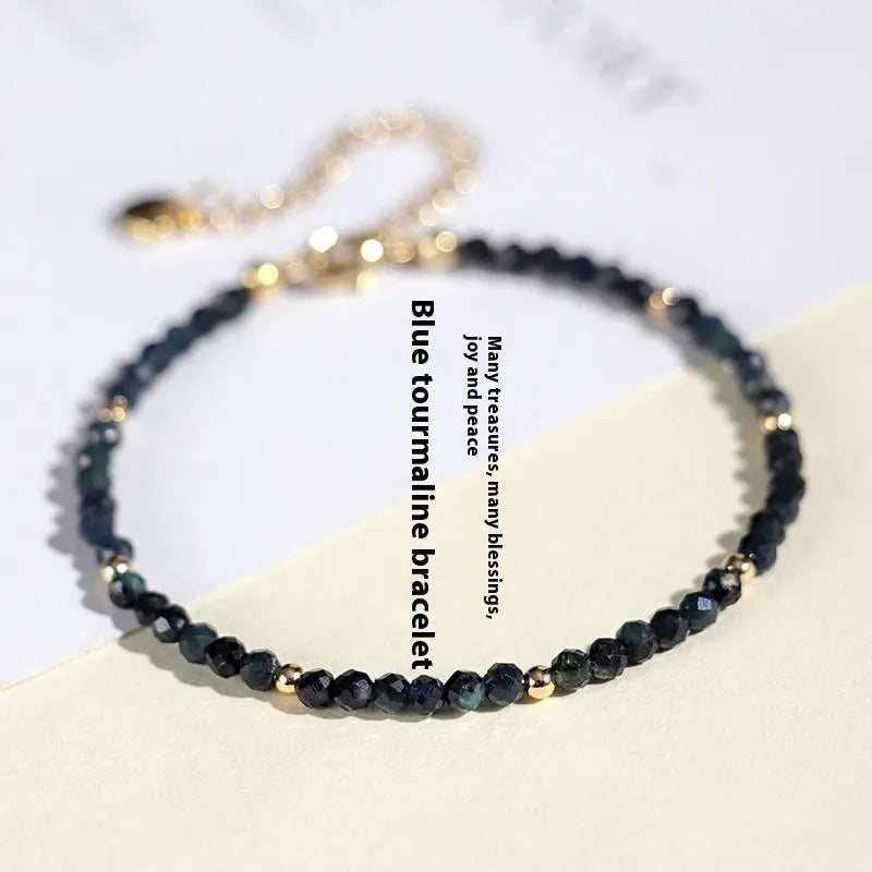 Blue tourmaline gemstone bracelet with 3mm beads and gold spacer details.