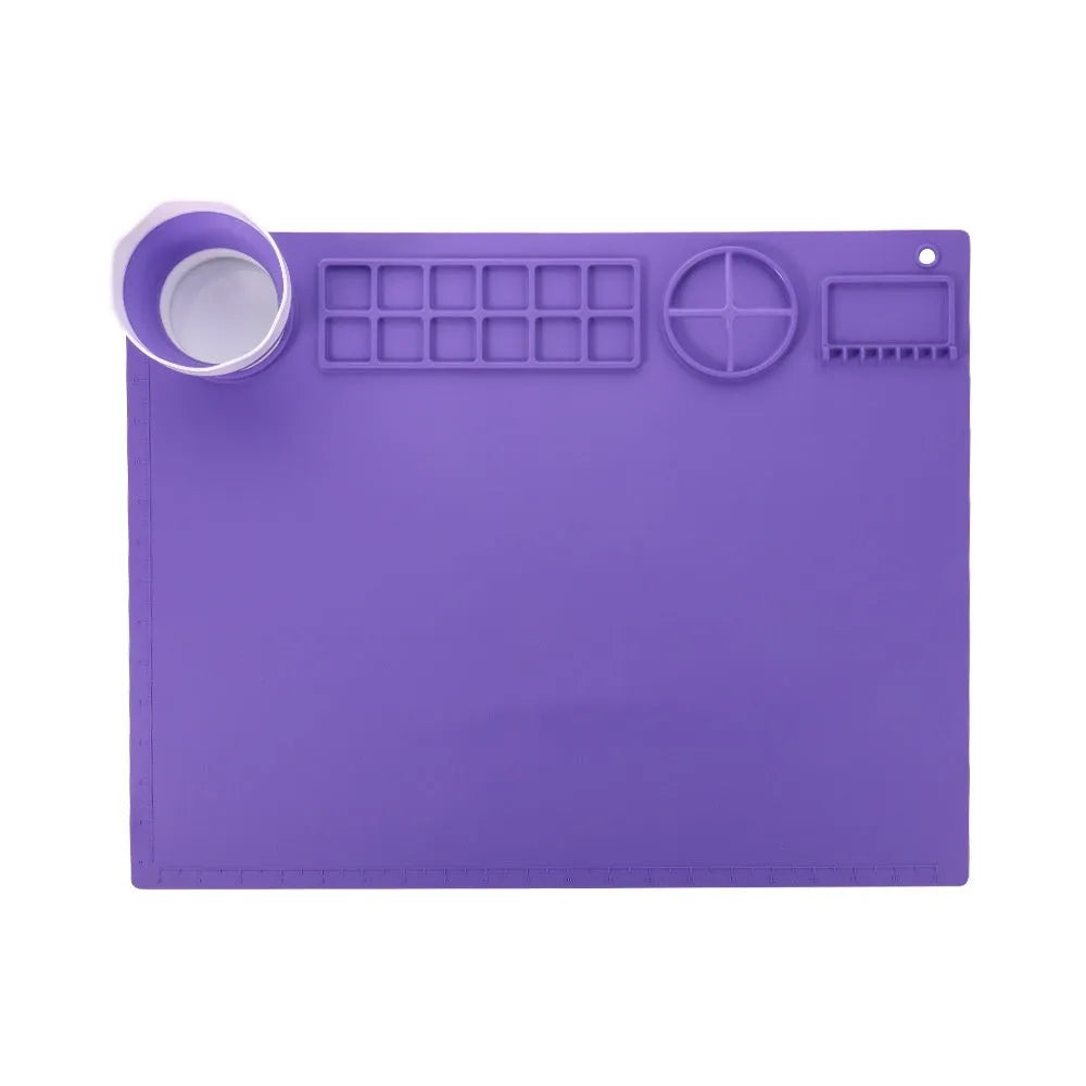 Light blue silicone painting mat measuring 50 by 40 centimetres with two round paint wells.