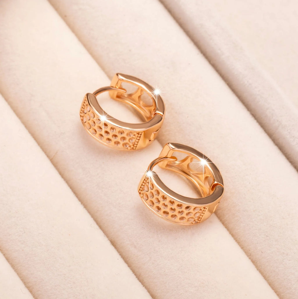 Rose gold hollowed out earrings with a three-heart design inside a circular shape.