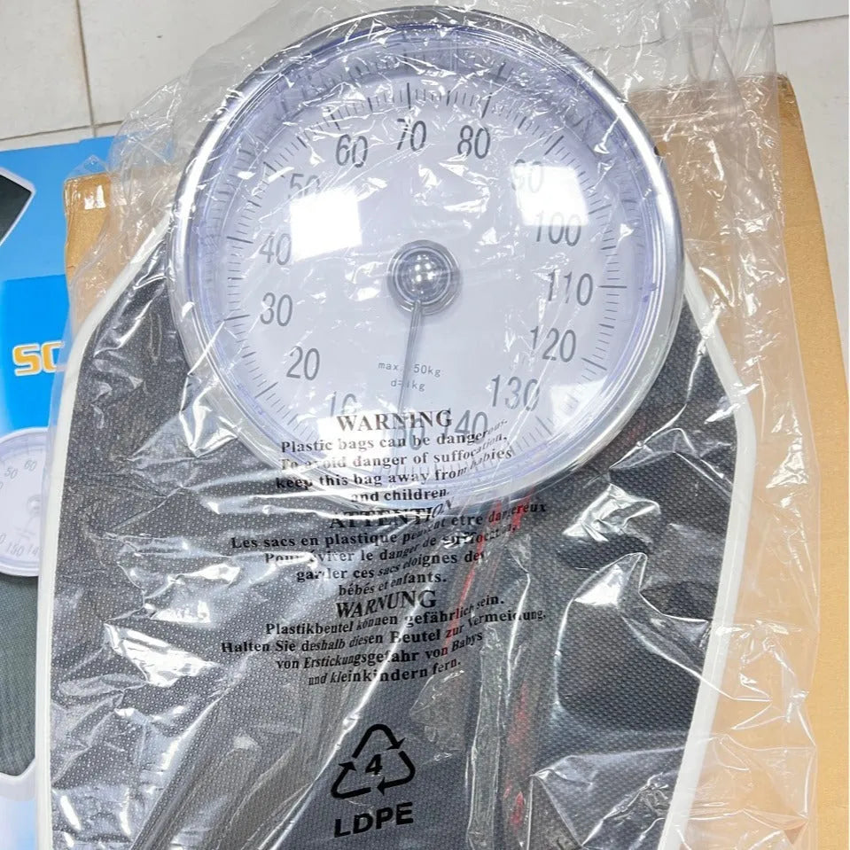 Black mechanical body weight scale with large analogue dial on a simple platform.