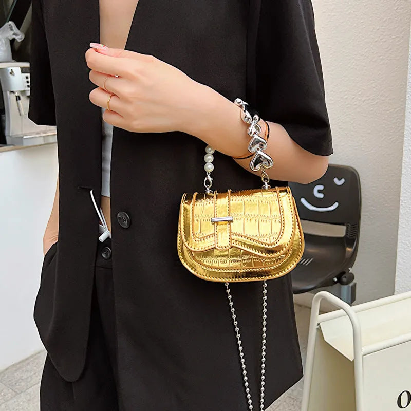 Laser pearl finish mini tote saddle crossbody bag in a choice of colours, shown with a single strap and structured square shape.