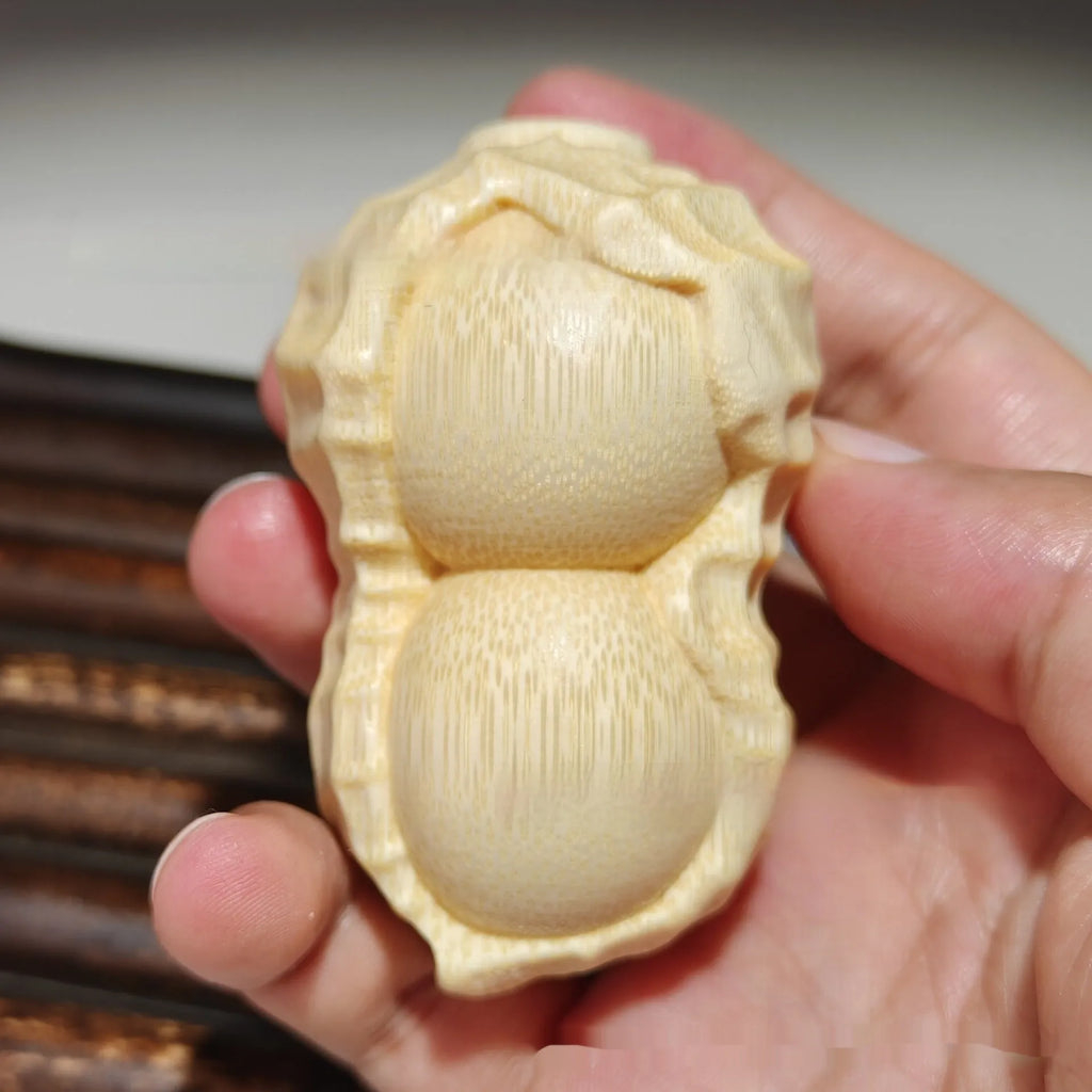 Modern simplicity style solid bamboo carving peanut ornament on a neutral background.