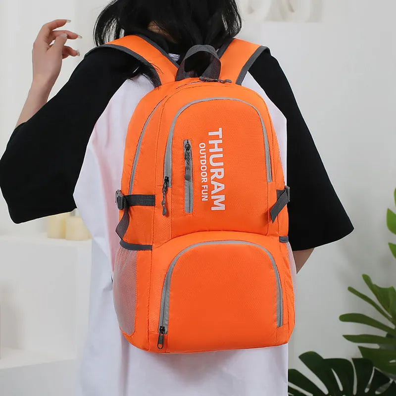 Outdoor folding rucksack in dark blue with air pillow belt system showing 20-35 litre capacity