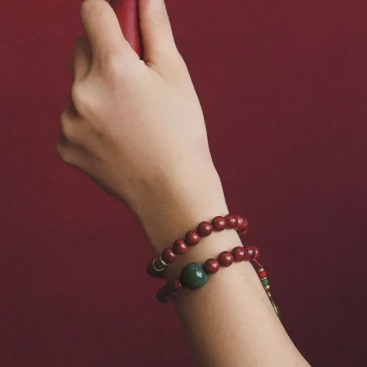 Handmade bodhi seed double circle bracelet with cartoon style on a wrist.