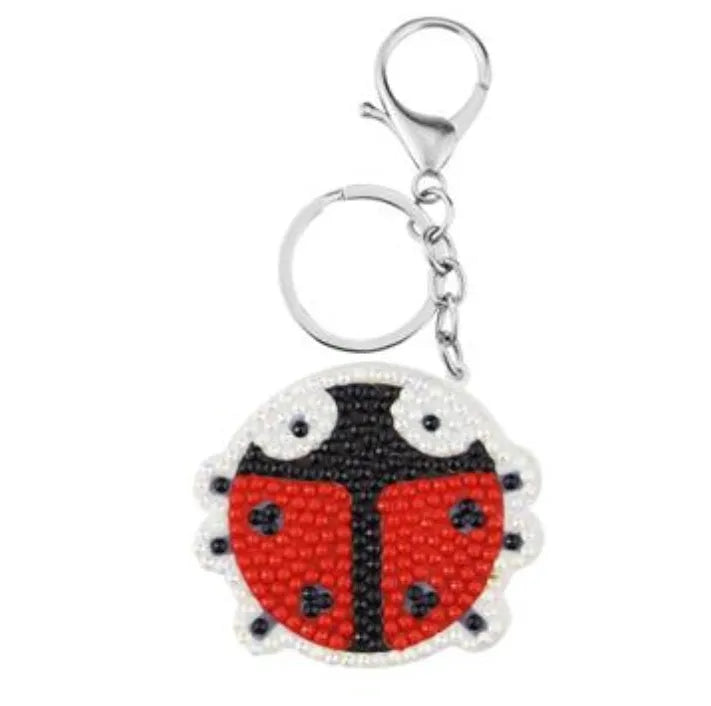 Diamond painting keychain craft kit with four style options: ladybird, Santa Claus, unicorn, on a white background