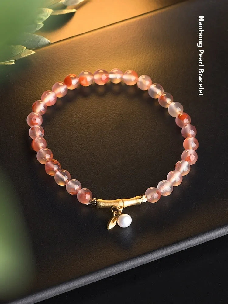 Ice float nanhong agate bracelet with floral shape and bamboo joint design on a wrist.