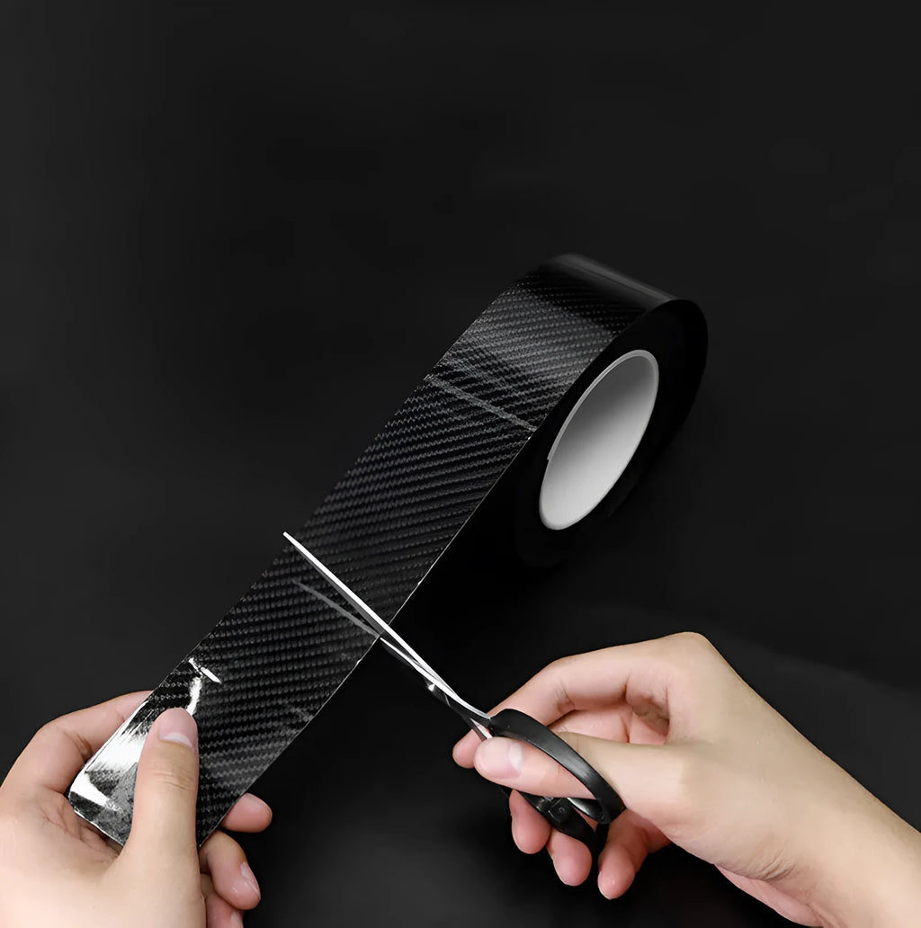 Black carbon fiber self-adhesive anti-collision decorative strip roll for car door threshold and bumper edge protection.