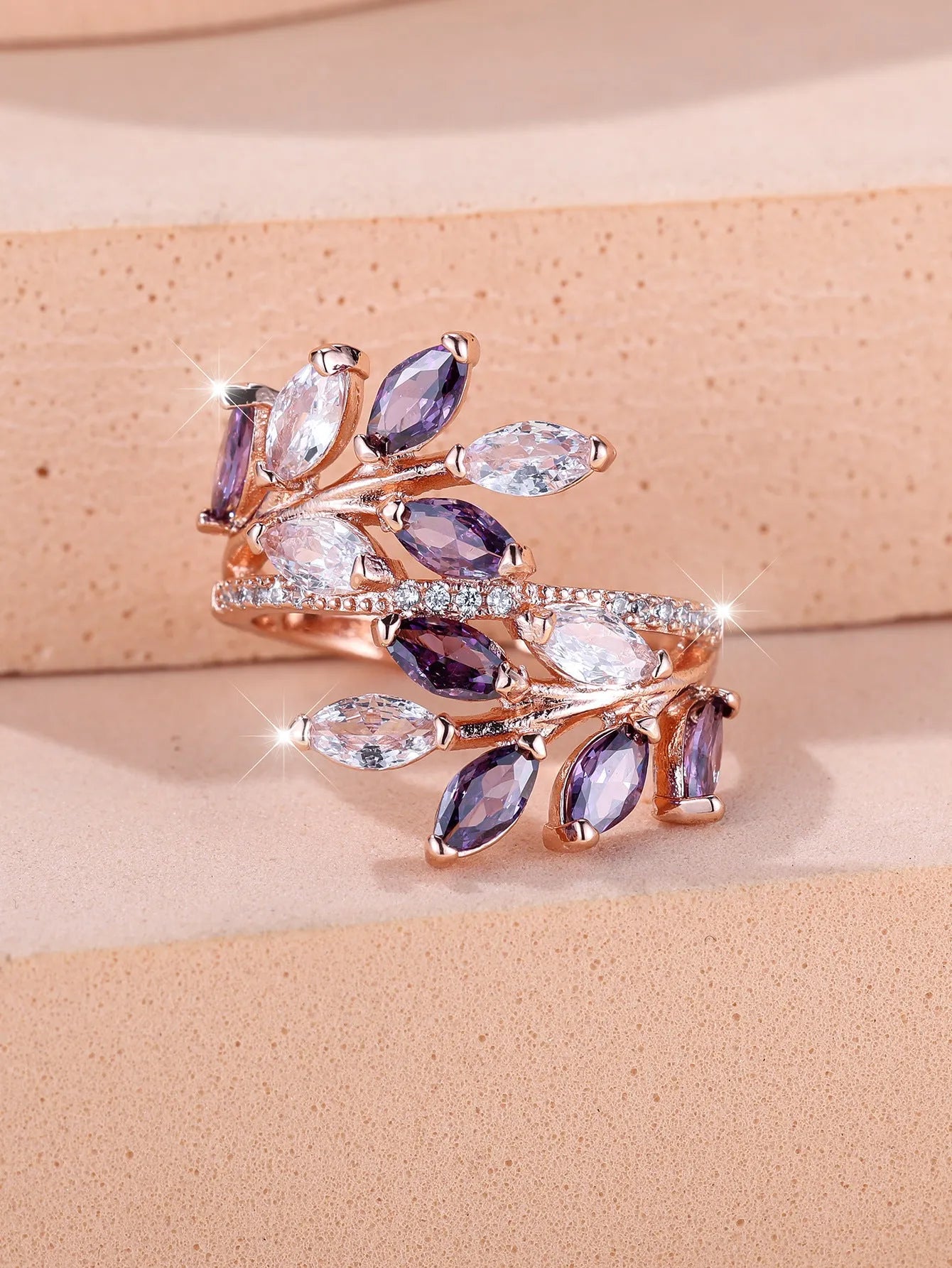 Adjustable open-ended leaf-shaped ring with zirconia stones on a copper band.
