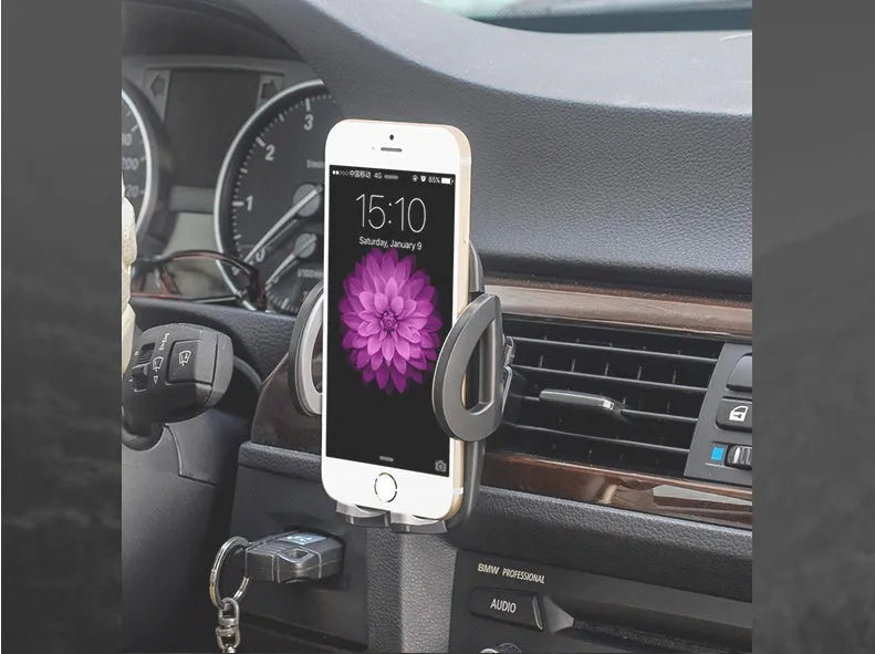 Black plastic mobile phone holder mounted on car air conditioning vent with phone in cradle