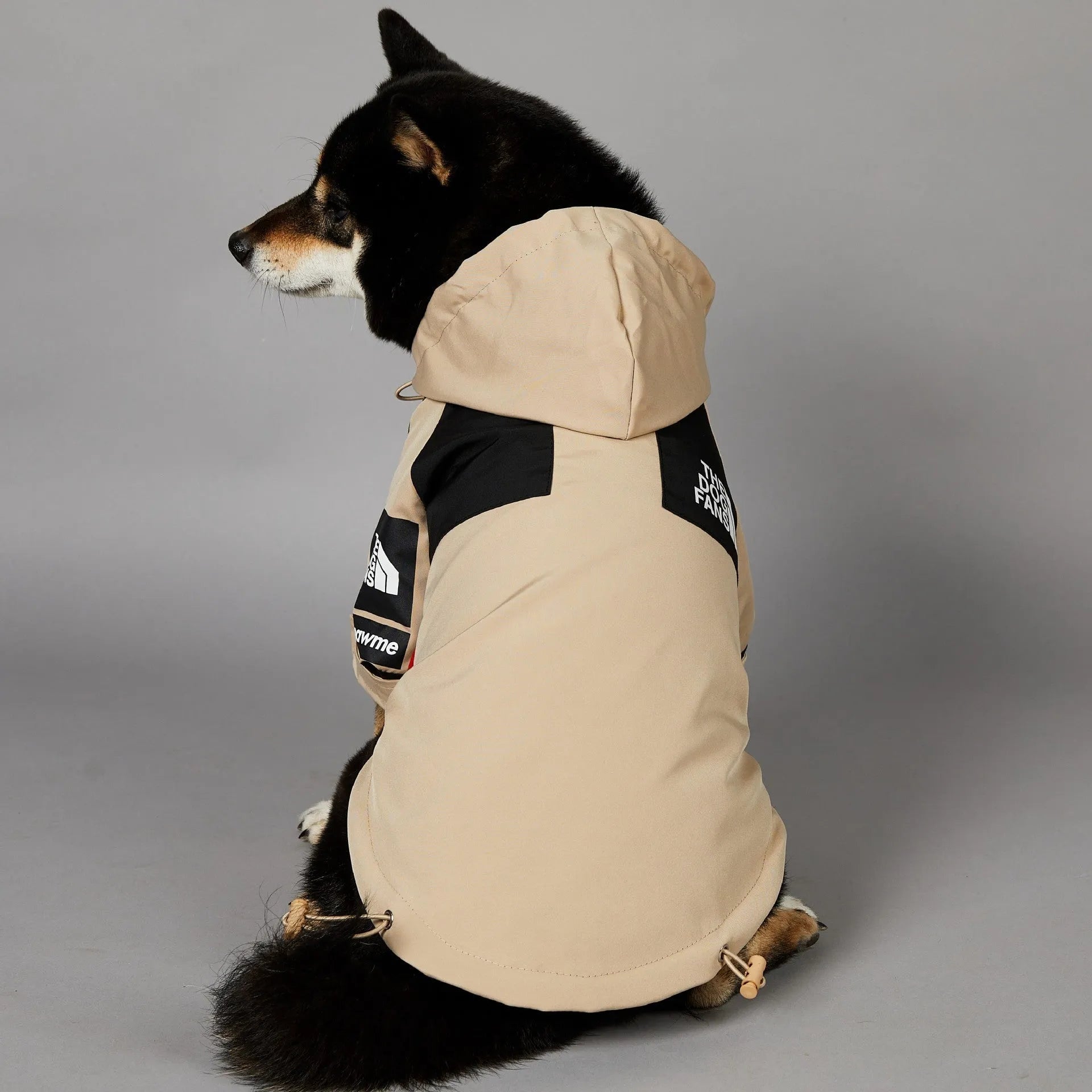 Khaki coloured polyester shell jacket for a dog on a size chart showing S, M, L, XL, 2XL, 3XL, 4XL, and 5XL.